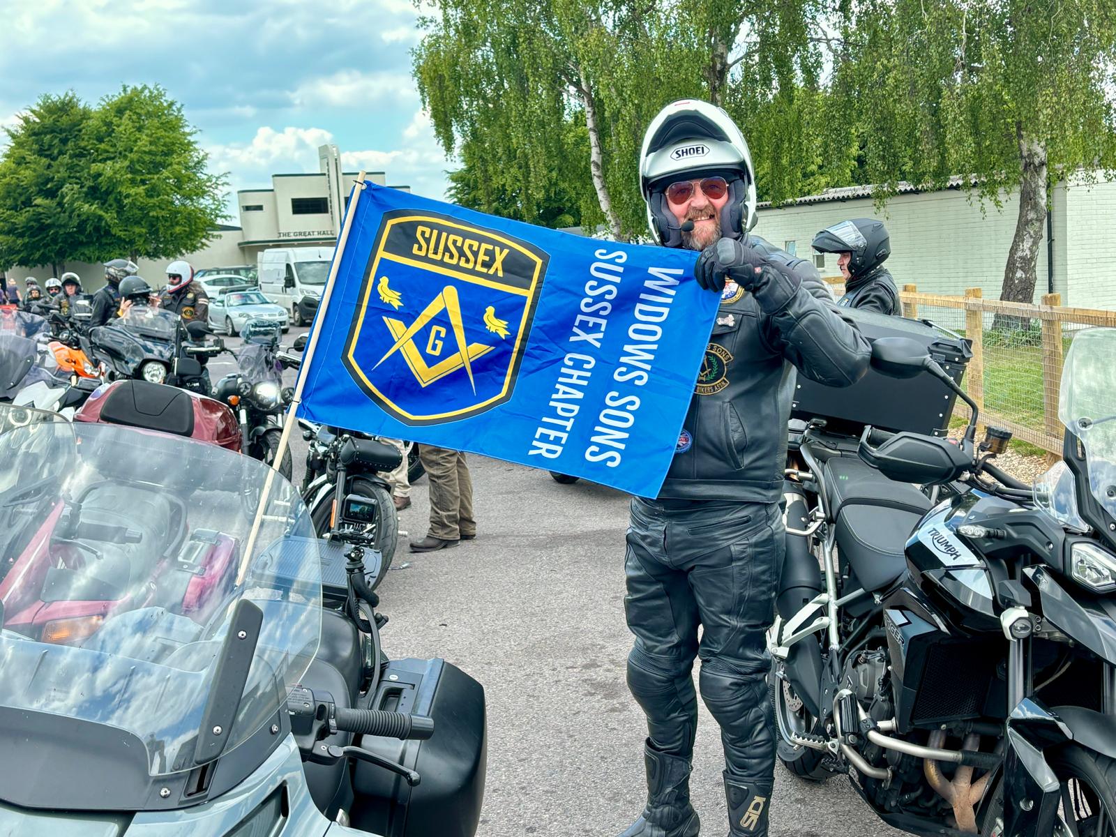 A Sussex Chapter rider holding the chapter flag at Goodwood